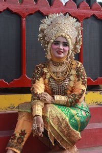 Woman wearing traditional clothing while sitting outdoors