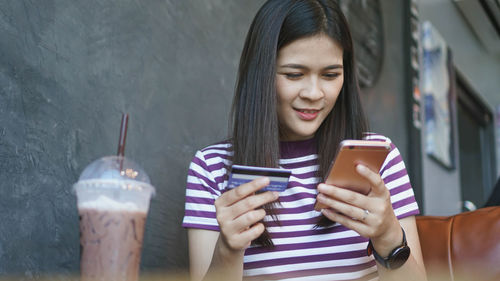 Portrait of young woman using mobile phone outdoors