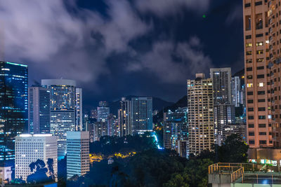 Illuminated buildings in city against sky at night