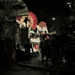 Rear view of people standing on street at night