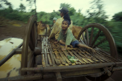 People sitting on boat against trees