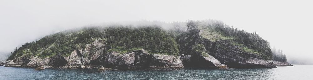 View of rocks in sea against sky