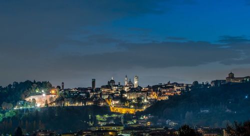 Illuminated buildings in city against sky