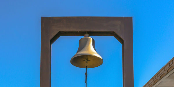 Low angle view of electric lamp against blue sky