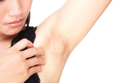 Close-up of woman touching hand over white background