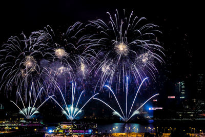 Firework display over river at night