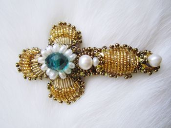 Close-up of cross shape jewelry on white fur