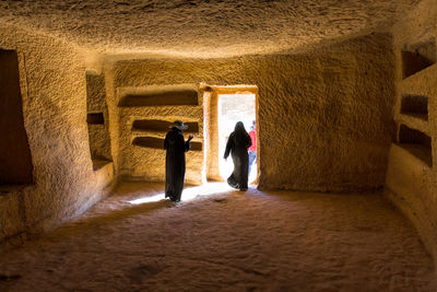 Rear view of woman walking in tunnel