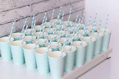 High angle view of disposable cups with straws on table