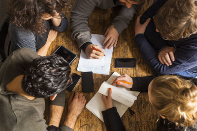 Coworkers working on a project on wooden table