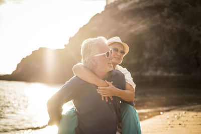 Cheerful couple enjoying on beach during sunset