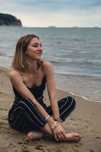 Portrait of young woman sitting at beach