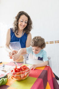 Close-up of woman and son preparing food