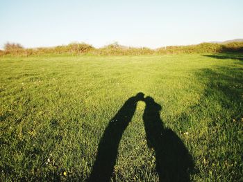 Shadow of couple kissing on field