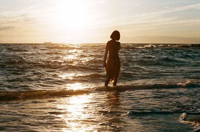 Young woman standing in water at beach