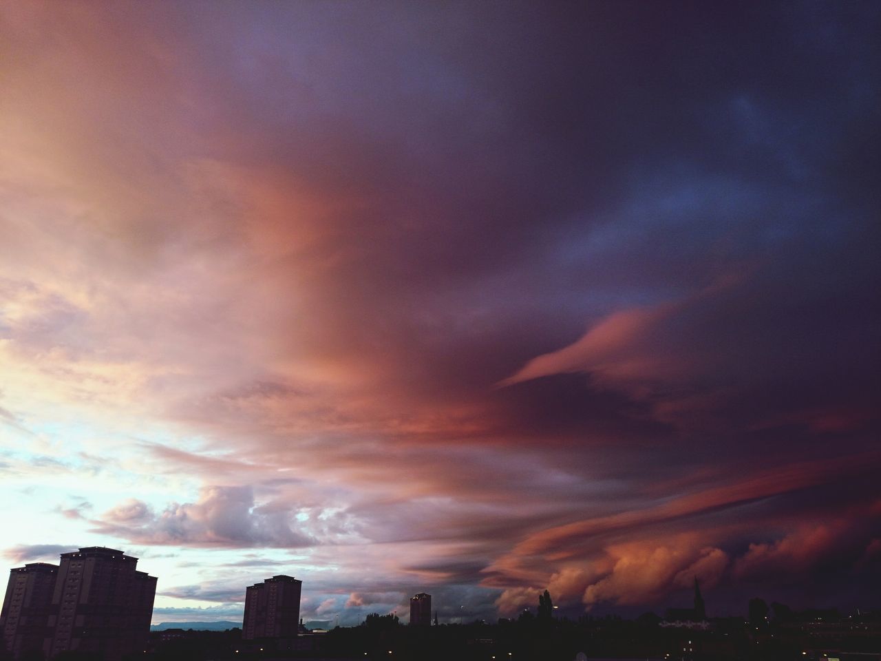 sky, building exterior, cloud - sky, architecture, built structure, sunset, cloudy, silhouette, city, weather, dramatic sky, overcast, cityscape, storm cloud, cloud, scenics, beauty in nature, dusk, nature, atmospheric mood