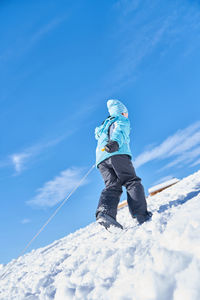 Low angle view of child on snow covered landscape
