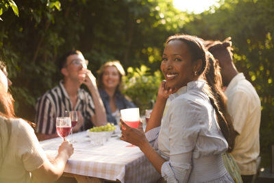 Side view of friends sitting on table