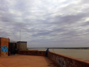 View of calm lake against cloudy sky