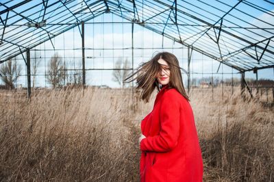 Portrait of young woman standing on field