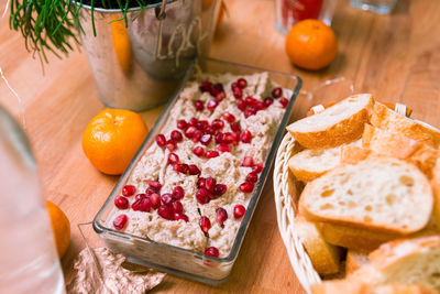 Tuna pate sprinkled with pomegranate seeds and a basket with slices of bread for spreading