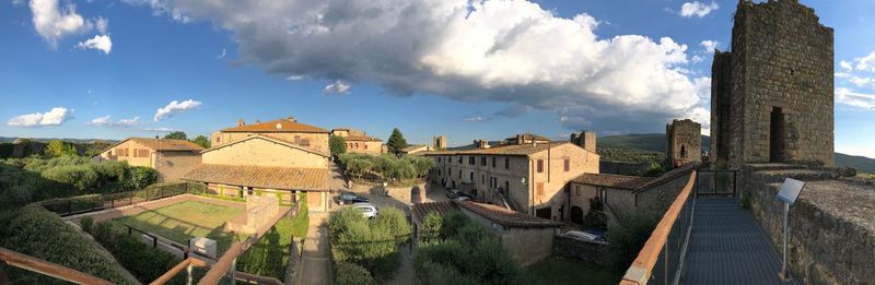 Panoramic view of buildings by river against sky