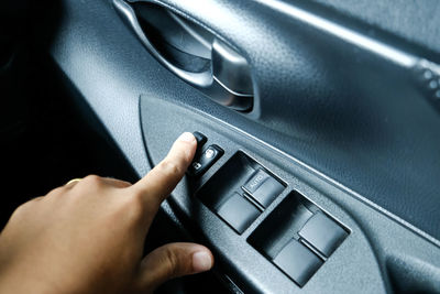 Close-up of hand using push button in car