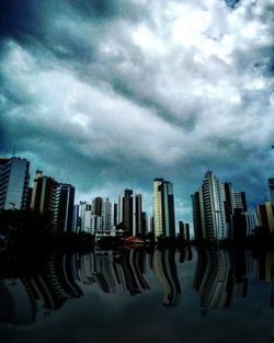 Buildings in city against cloudy sky