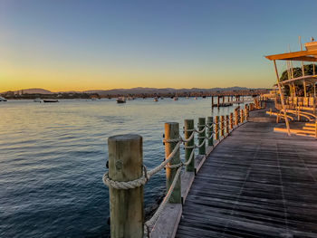 Pier over sea against sky during sunset