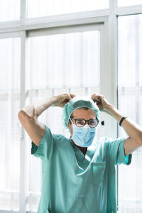 Surgeon putting on mask