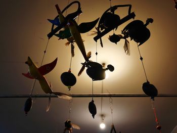 Low angle view of silhouette lanterns hanging against sky