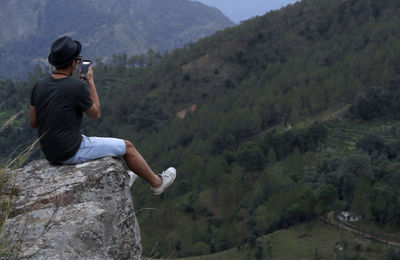 Man on rock against mountains