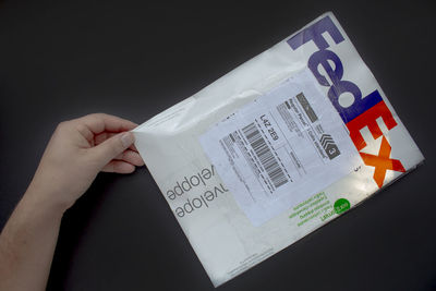 High angle view of person hand holding paper against black background