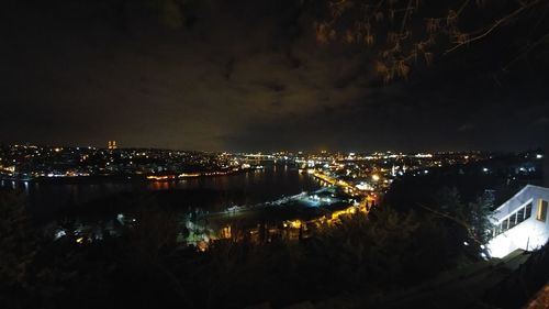 Illuminated cityscape against sky at night