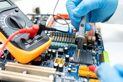 Close-up of hands repairing computer chip