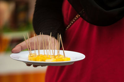 Close-up of human hand holding ice cream on plate