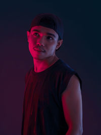 Portrait of young man against black background
