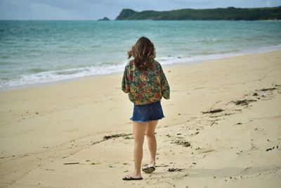 Rear view of woman standing on beach