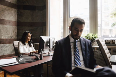 Male and female financial advisors working at law office