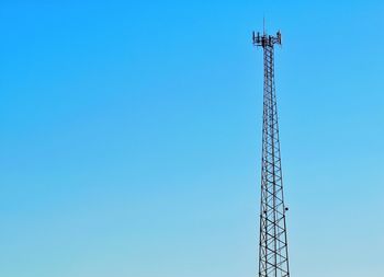 Low angle view of crane against clear blue sky