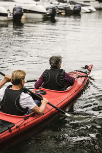 Rear view of people on boat in river