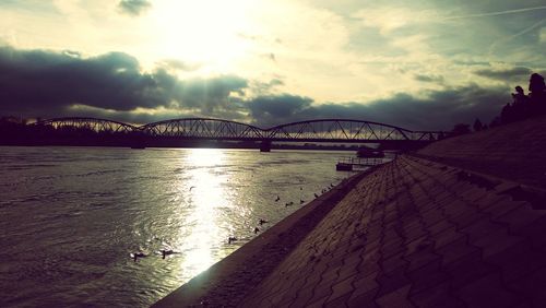 Bridge over river in city against sky