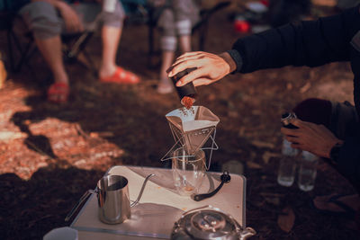 Close up photo of man preparing coffee at camping in forest.