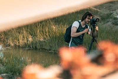 Rear view of man photographing with camera