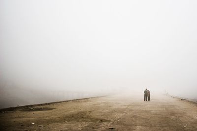 People at standing on road in foggy weather