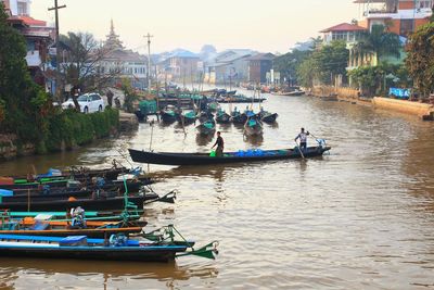 Boats in river against buildings in city