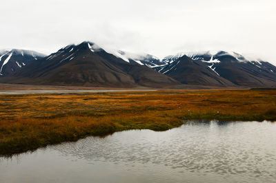 Scenic view of lake and mountains against sky