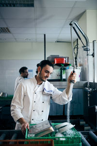 Chef spraying water on plates in commercial kitchen