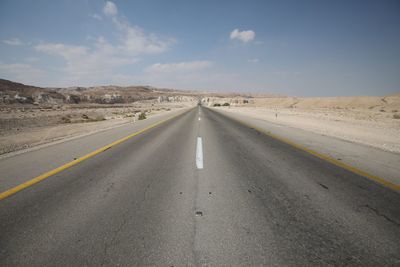 Road passing through landscape against sky