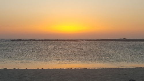 Scenic view of sea against orange sky